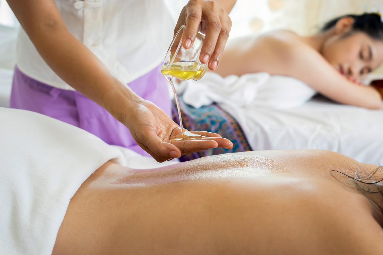 Terapis D'Palasan menuangkan minyak aromaterapi sebelum sesi spa
